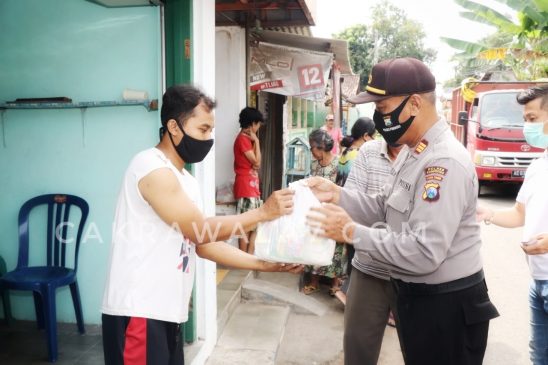 Foto : Anggota Polres Ponorogo bagikan sembako secara Dor to dor kepada warga yang terdampak covid-19